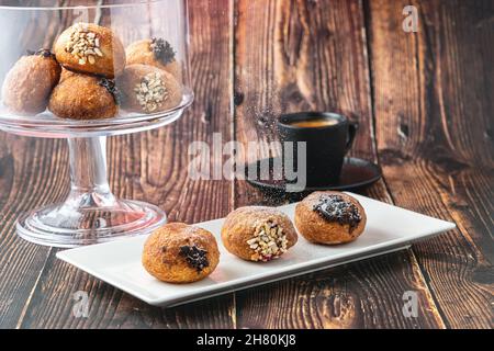 Bombolon oder Bomboloni ist ein italienisches gefülltes Donut- und Snackfutter. Deutsche Krapfen - Krapfen oder berliner - gefüllt mit Marmelade und Schokolade Stockfoto