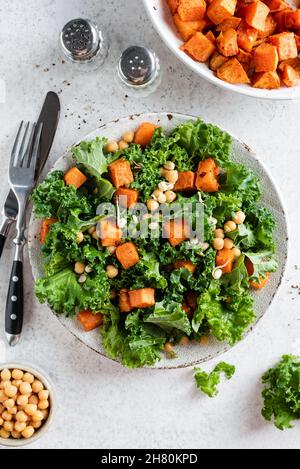 Gesunder veganer Salat mit gerösteter Süßkartoffel und Grünkohl. Tabellenansicht von oben Stockfoto