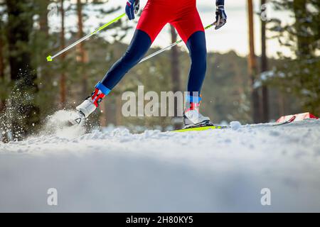 Der männliche Skifahrer fährt beim Langlaufen bergauf Stockfoto