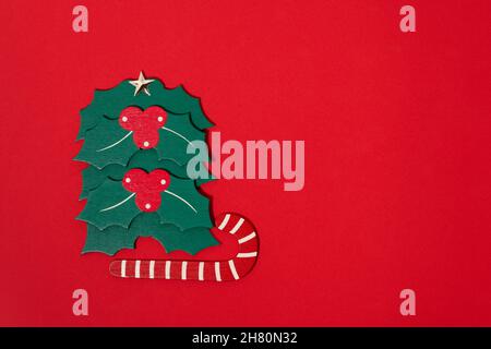 Weihnachtsschlitten mit Weihnachtsbaum auf rotem Hintergrund. Frohe weihnachten Happy New year Feiertag Feier Konzept Grußkarte Hintergrund. Stockfoto