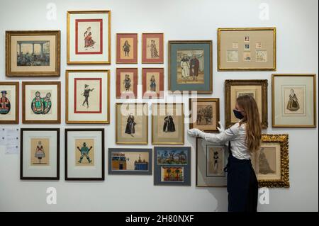 London, Großbritannien. 26. November 2021. Ein Techniker präsentiert eine Sammlung von Illustrationen bei einer Vorschau auf Sothebys bevorstehende russische Kunstverkäufe. Die Werke werden am 30. November und 1. Dezember in Sothebys New Bond Street Galerien versteigert. Kredit: Stephen Chung / Alamy Live Nachrichten Stockfoto