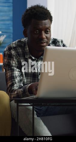 Junges interrassisches Paar, das Steuern und Papierkram mit Laptop und Notebook im Wohnzimmer berechnet. Ehemann und Ehefrau aus gemischter Rasse überprüfen Rechnungen und planen das Budget für Steuerzahlungen zu Hause Stockfoto