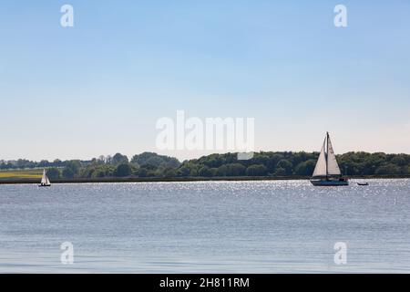 Woodbridge, Suffolk, UK Mai 29 2021: Eine große Yacht und ein kleines Segelboot auf dem Fluss Deben Stockfoto