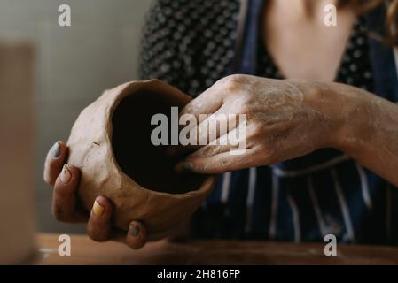 Die Hände der Potter-Frau arbeiten mit Ton. Wir machen eine Tonschale durch Formen. Weibliches Hobby-Konzept Stockfoto