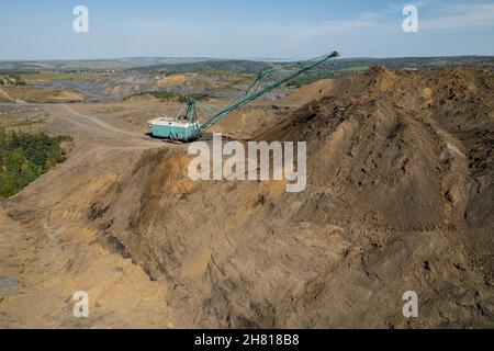 Großer Bagger entfernt Boden, um Kohle zu extrahieren, Luftdrohne Draufsicht. Stockfoto