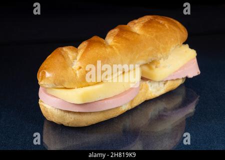 Sandwich mit Wurst und Käse auf dem Tisch mit einer Reflexion. Essen auf schwarzem Hintergrund Stockfoto