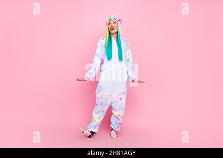 In voller Länge Körpergröße Ansicht der attraktiven fröhlichen Mädchen trägt Kigurumi tanzen Spaß isoliert über rosa Pastellfarbe Hintergrund Stockfoto