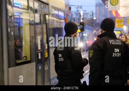 Leipzig, Deutschland. 26th. November 2021. Polizeibeamte und Transitinspektoren stehen an einer Bushaltestelle. Die Beamten kontrollieren die Corona-Schutzverordnung im öffentlichen Verkehr. Ab dem 23. November 2021 gelten dort die Regeln von 3. Passagiere müssen geimpft, getestet oder geborgen werden. Quelle: Sebastian Willnow/dpa-Zentralbild/dpa/Alamy Live News Stockfoto