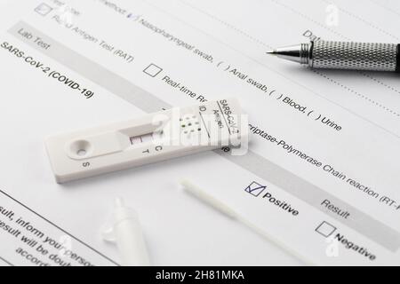 Nahaufnahme des positiven Ergebnisses durch schnellen Antigentest auf SARS-CoV-2, COVID-19, auf einem Testdokument. COVID-19, Tests, Medizin, Pandemie und Sicherheit Stockfoto