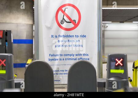 London, Großbritannien. 26. November 2021 Hinweisschild an der Canary Wharf Station warnen Pendler: Es ist verboten, E-Scooter auf Bahnhöfen oder Zügen in London U-Bahn zu fahren, Teil von Transport for London. Kredit: Xiu Bao/Alamy Live News Stockfoto