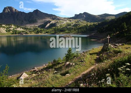 Holzkreuz am Ufer des Lac d'Allos an einem späten Julinachmittag (Mercantour Park, Alpes-de-Haute-Provence, Frankreich) Stockfoto