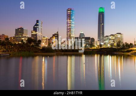 Teich im Bicentennial Park in den wohlhabenden Vitacura Bezirk und Skyline von Gebäuden im Bankenviertel, Santiago de Chile Stockfoto