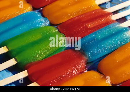 Reihen von bunten schmelzenden Eis am Stiel in der Sommerhitze auslegen Stockfoto
