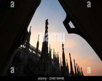 Mailand, Lombardei, Italien. Dezember 2019. Einige der 96 riesigen Steinstatuen auf den Wasserspeiern der Mailänder Kathedrale bei Sonnenuntergang. Stockfoto