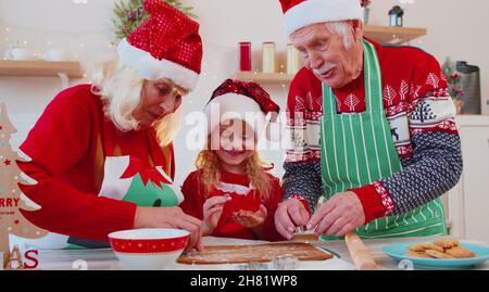 Ältere Familie Großmutter, Großvater, Enkelin Vorbereitung, Kochen hausgemachte Weihnachtskekie Stockfoto