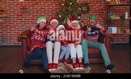 Lachende Familie winkt mit den Händen hallo, hallo, Gruß, während sie Selfie auf dem Smartphone zu Weihnachten zu Hause macht Stockfoto