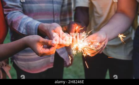 Fröhliche Freunde feiern zusammen mit Wunderkerzen am Silvesterabend Stockfoto