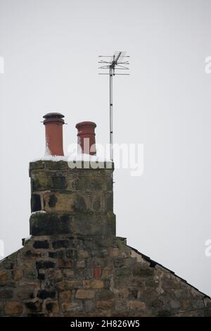 Schornsteine mit terrestrischer Fernsehantenne auf einem Haus im Winter, England, Vereinigtes Königreich Stockfoto