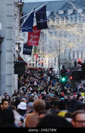 London, Großbritannien, 26th. November 2021. Starke Besucherfrequenz entlang der Regent Street, da Einzelhändler am Black Friday einen Schub erhalten. Bis Sonntagmorgen schienen die mit festlichen Einkäufen beladenen Käufer vom U-Bahn-Streik von Transport for London (TfL), der fünf U-Bahnlinien betrifft, nicht abgeschreckt zu sein. Regent Street und Oxford Street starteten langsam, aber am Nachmittag war es voller Menschen. Kredit: Elfte Stunde Fotografie/Alamy Live Nachrichten Stockfoto