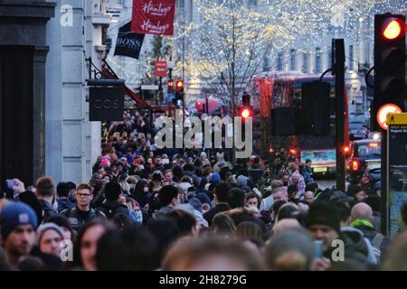 London, Großbritannien, 26th. November 2021. Starke Besucherfrequenz entlang der Regent Street, da Einzelhändler am Black Friday einen Schub erhalten. Bis Sonntagmorgen schienen die mit festlichen Einkäufen beladenen Käufer vom U-Bahn-Streik von Transport for London (TfL), der fünf U-Bahnlinien betrifft, nicht abgeschreckt zu sein. Regent Street und Oxford Street starteten langsam, aber am Nachmittag war es voller Menschen. Kredit: Elfte Stunde Fotografie/Alamy Live Nachrichten Stockfoto