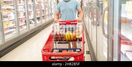 Cropped Mann mit Einkaufswagen kaufen Lebensmittel im Lebensmittelgeschäft, Einkaufen Stockfoto