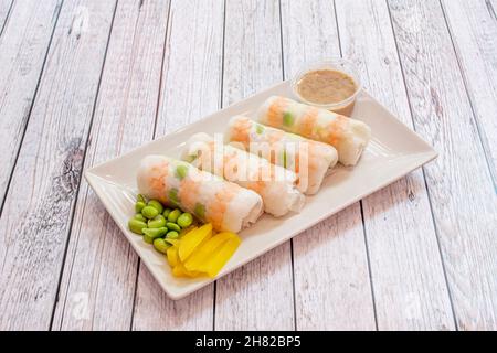 Sushi-Tablett aus Glas mit Krabben, Edamamabohnen, gelbem Pfeffer und Dip-Sauce Stockfoto