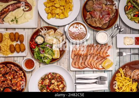 Set von großen Gerichten der spanischen Küche und Tapas, gegrillte Garnelen, Tintenfisch mit Kartoffeln, würzige Bravas, gegrillte Tintenfische, Ohr, kroketten mit serrano-Schinken, m Stockfoto