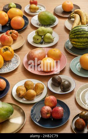 Viele verschiedene Gerichte mit vielen leckeren Früchten, roten Äpfeln, Birnen, Bananen, Tomaten, Avocados, Mangos und mehr Stockfoto