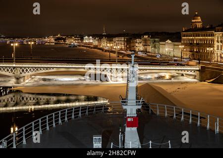 Die Panoramabilder der Winternachtstadt Sankt-Petersburg mit malerischen Spiegelungen auf dem Wasser, großes Schiff, das in der Nähe der Blagoweschtschenski Brücke oder festgemacht ist Stockfoto