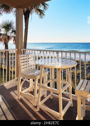 Tisch und Stühle auf einem Balkon mit Blick auf den Strand und das Meer oder den Golf von Mexiko in Florida, USA. Stockfoto