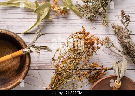Draufsicht auf verschiedene Kräuter für Körper- und Seelenheilung Homöopathie alternative Medizin auf Holztisch Stockfoto