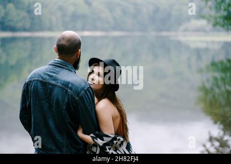 Frau hält Mann Arm, während sie am See steht. Nahaufnahme. Rückansicht Stockfoto