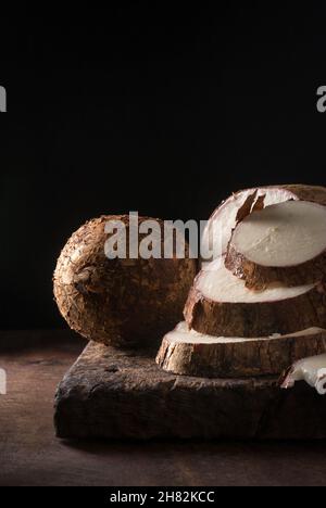 Cassava oder Manihot, auch bekannt als Manioc, Yuca oder Brazillian Pfeilwurzel, ganzes Wurzelgemüse und in Stücke geschnitten, fertig zum Kochen Stockfoto