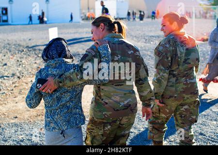 8. November 2021 - Joint Base McGuire-Dix-Lakehurst, New Jersey, USA - US Air Force Colon Bernadette Maldonado und LT. Col. April Doolittle, New Jersey Air National Guardsmen, die dem 108th Wing zugewiesen sind, gehen mit einem afghanischen Mädchen im Liberty Village auf Joint Base McGuire-Dix-Lakehurst, N.J., 8. November 2021. Das Verteidigungsministerium stellt über das US-Nordkommando und zur Unterstützung des Heimatschutzministeriums Transport, vorübergehende Unterbringung, medizinische Vorsorgeuntersuchungen und allgemeine Unterstützung für mindestens 50.000 afghanische Evakuierte in geeigneten Einrichtungen in permanenter oder temporärer Struktur bereit Stockfoto