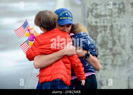 Seattle, Washington, USA. 20th. November 2021. Commander Philip Baxa, Operationsoffizier an Bord der US-Küstenwache Cutter Healy (WAGB-20), umarmt seine Familie am Pier der Base Seattle am Samstag, den 20. November. Commander Baxa und die Besatzung kamen nach einem 22.000 Meilen langen, 133-tägigen Einsatz um Nordamerika in ihrem Heimathafen Seattle an. Quelle: U.S. Coast Guard/ZUMA Press Wire Service/ZUMAPRESS.com/Alamy Live News Stockfoto