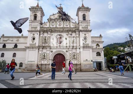 Tegucigalpa, Honduras. 26th. November 2021. Kinder füttern die Tauben vor einer Kirche.die Republik Honduras wird am 28th. November Parlamentswahlen abhalten, um eine neue Gruppe von Präsidenten-, Kongress- und Kommunalregierungen zu wählen. Kredit: SOPA Images Limited/Alamy Live Nachrichten Stockfoto