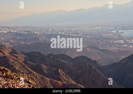 Shlomo Salomon Berg. Blick auf die Eilat-Berge. Vor dem Hintergrund des Aqaba-Gebirges, Jordanien. Die Berge, die Stadt und der Hafen. Rotes Meer. Eilat Israel. Hochwertige Fotos Stockfoto