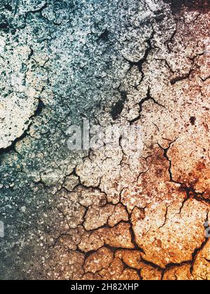 Grunge- oder Texturhintergrund von trockener und rissiger Oberfläche mit goldenem Farbton und Kopierraum Stockfoto