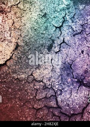 Grunge- oder Texturhintergrund von trockener und rissiger Oberfläche mit grünen und violetten farbigen Farbton und Kopierraum Stockfoto
