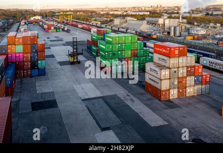 Luftaufnahme eines stark frequentierten Schiffscontainer-Bahnterminals in Leeds mit Schiffscontainern, die darauf warten, auf den Straßen- und Schienenverkehr verladen zu werden Stockfoto