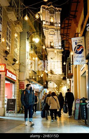 Malaga, Spanien. 26th. November 2021. Während der Einweihung der Weihnachtsbeleuchtung in Malaga werden Menschen in einer Gasse spazieren gesehen. Kredit: SOPA Images Limited/Alamy Live Nachrichten Stockfoto