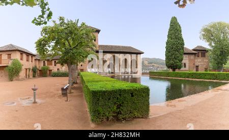 Alhambra Granada Spanien - 09 14 2021: Blick auf den Partal Palast oder Palacio del Partal , eine palastartige Struktur rund um Gärten und Wassersee im Inneren der A Stockfoto