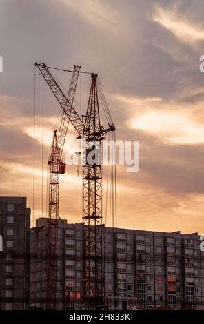 Turmdrehkran auf einer Baustelle bei Sonnenaufgang Stockfoto