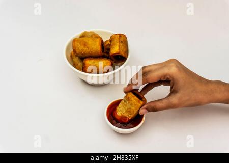Kartoffelrolle In Der Hand In Tomatensauce Tauchen Stockfoto
