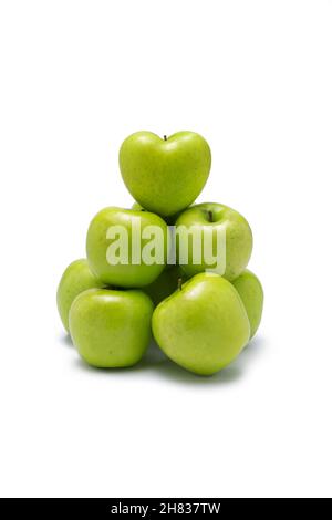 Grüne Äpfel, gestapelt in einer Gruppe mit einem Herz auf der Oberseite. Auf weißem Hintergrund. Stockfoto