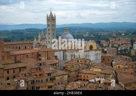 Mittelalterliche Kathedrale der Himmelfahrt der seligen Jungfrau Maria (Duomo di Siena) im Stadtbild an einem bewölkten Septembertag. Siena, Italien Stockfoto
