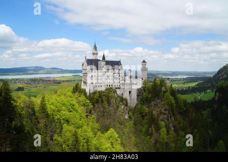 Bayerisches Schloss Neuschwanstein in den Alpen und Forggensee im Hintergrund fotografiert von der Marienbrücke (Bayern, Deutschland) Stockfoto