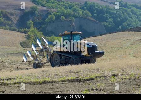 TOSKANA, ITALIEN - 23. SEPTEMBER 2017: 2K11 Raupentraktor Challenger MT775E mit einem Pflug auf den Hügeln der Toskana an einem sonnigen Herbsttag Stockfoto