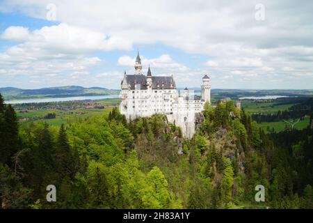 Bayerisches Schloss Neuschwanstein in den Alpen und Forggensee im Hintergrund fotografiert von der Marienbrücke (Bayern, Deutschland) Stockfoto