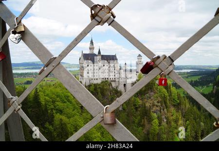 Bayerisches Schloss Neuschwanstein in den Alpen und Forggensee im Hintergrund fotografiert von der Marienbrücke (Bayern, Deutschland) Stockfoto